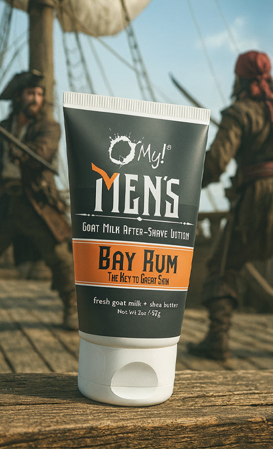 Tube of O My! Men's Goat Milk After-Shave Lotion of Bay Rum on a wooden surface with a historical background.