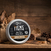 Men's O My! Goat Milk Beard Balm container on a wooden surface with natural elements.