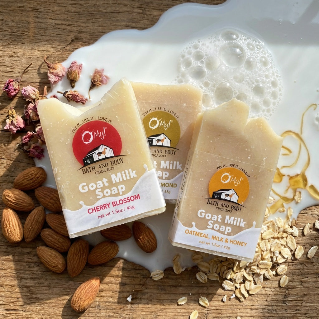 Three O my! goat milk traveler soap bars with visible branding on a wooden surface with almonds and oats.