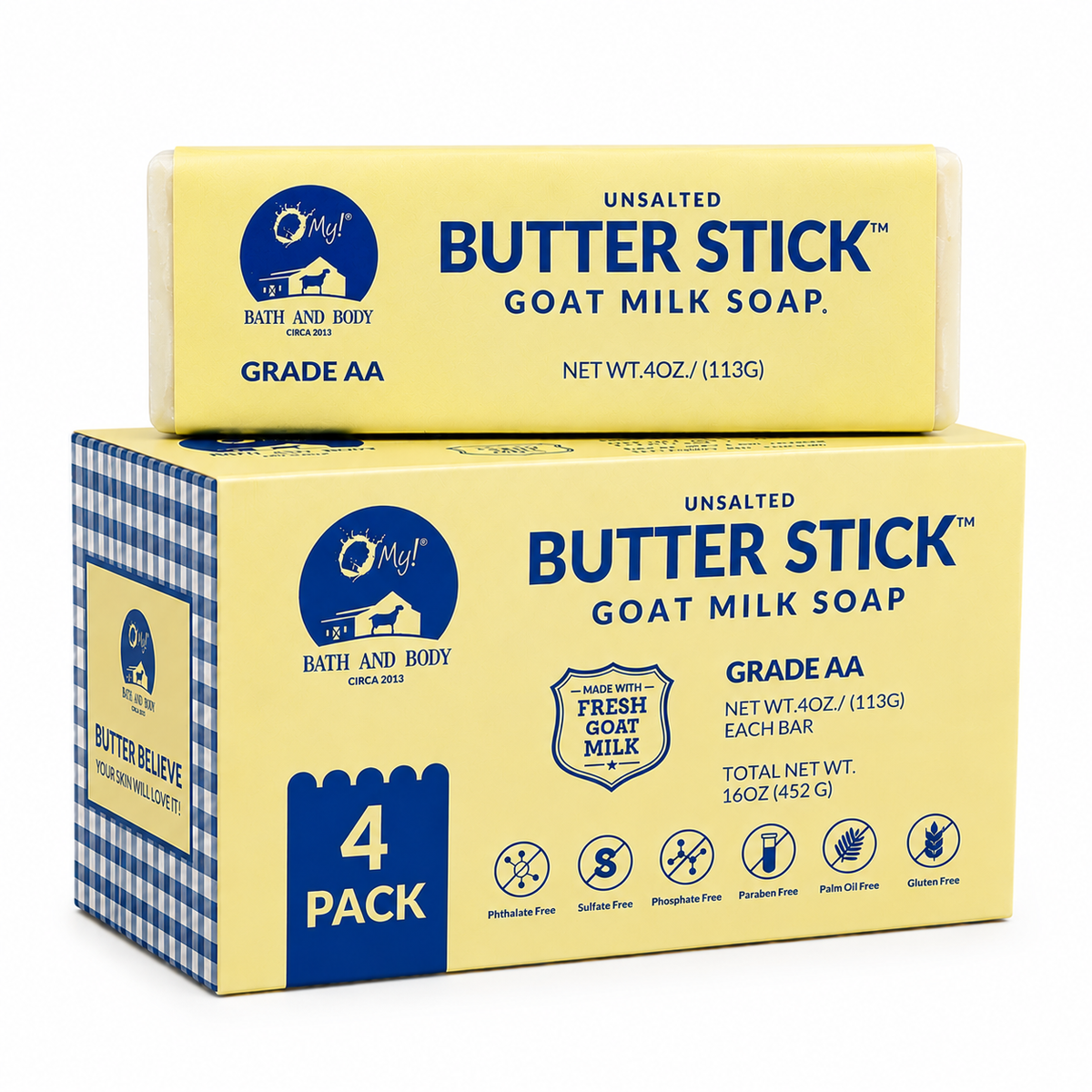 A 4-pack box of O My! Bath and Body Butter Stick Goat Milk Soap, Fragrance Free, with one individual bar sitting on top of the box. The packaging features a pale yellow face with blue text and a blue-and-white gingham pattern on the side panel.