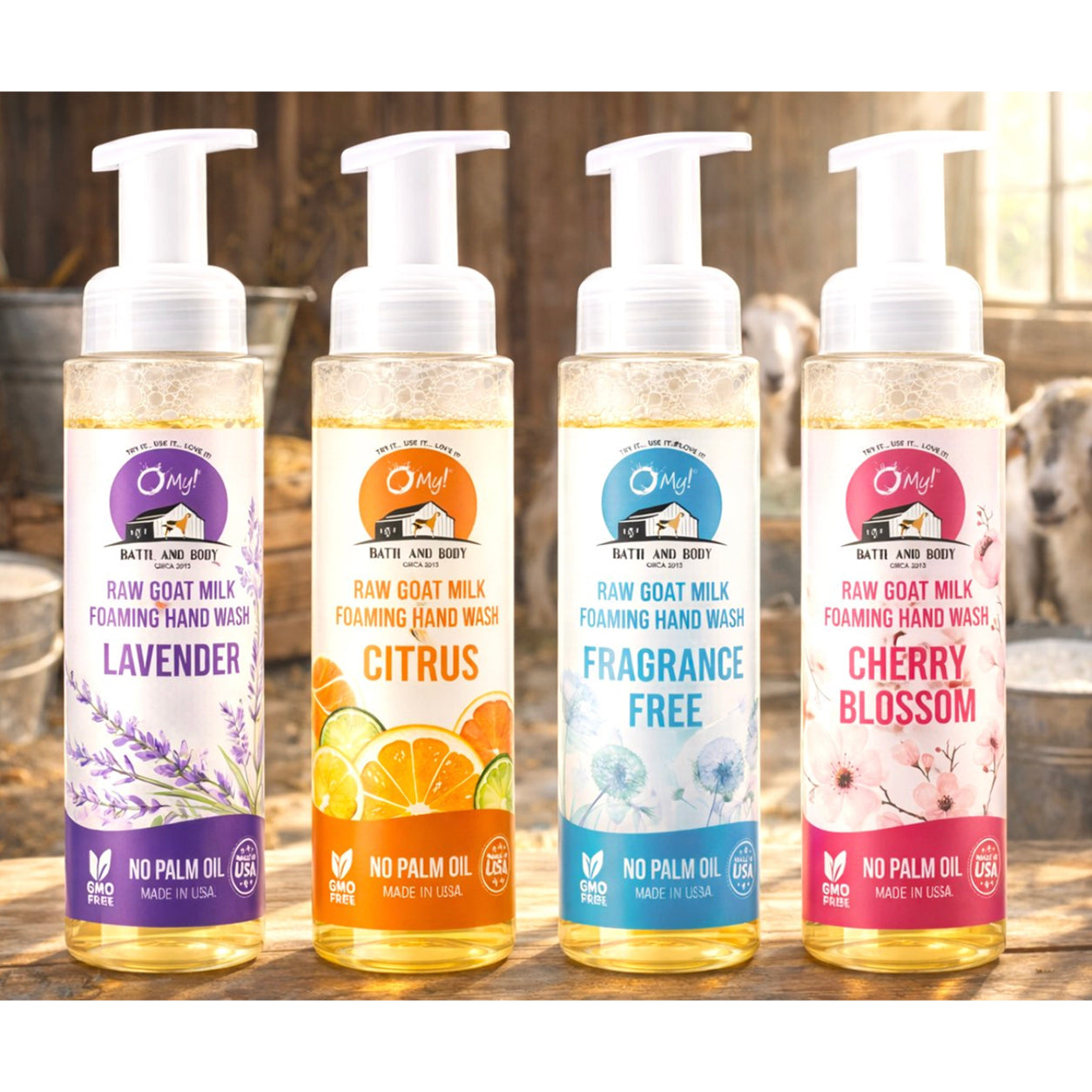 O My! Goat Milk Foaming Hand Wash lined up in a barn setting with goats and goat milk in the background.