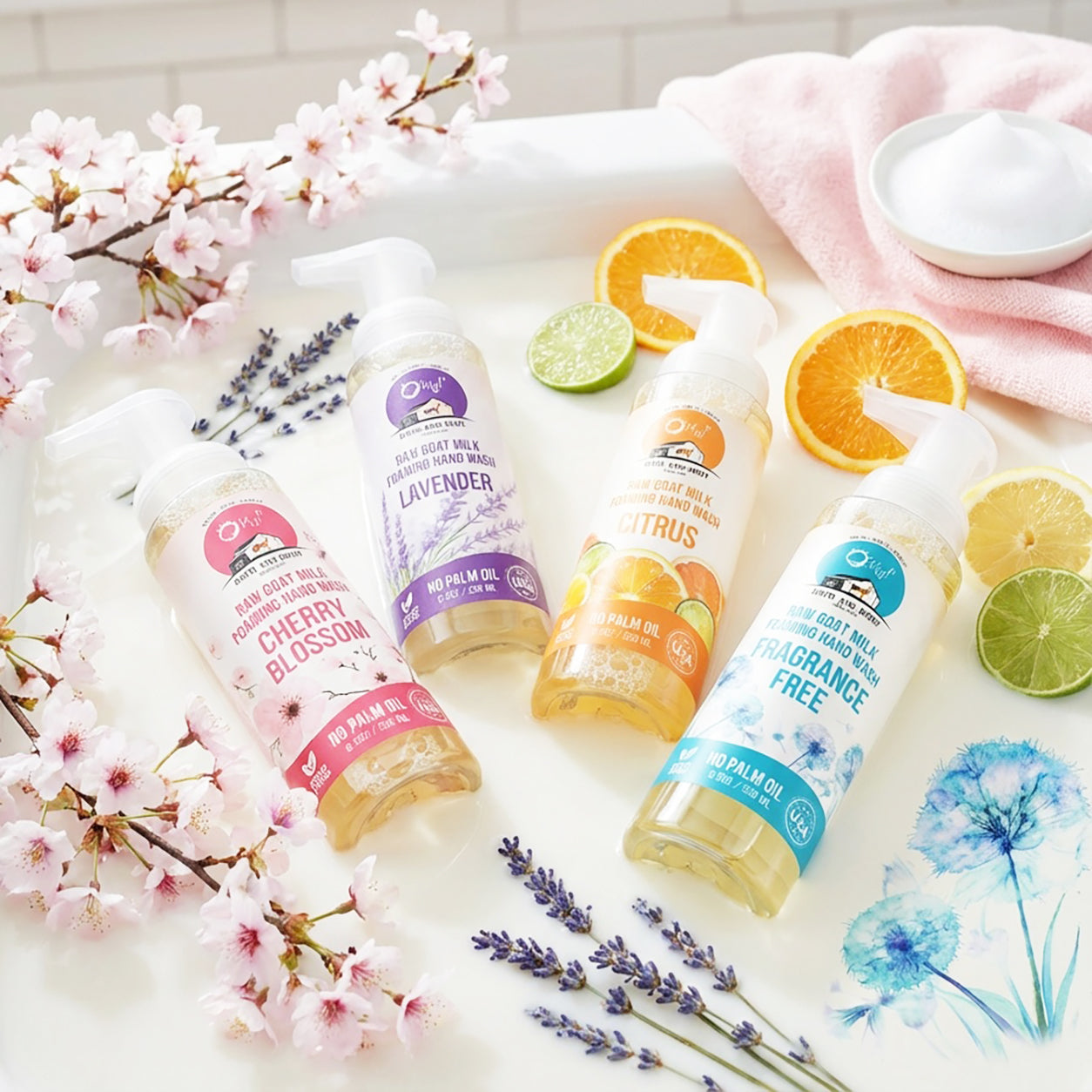 O My! Goat Milk Foaming Hand Wash bottles laying in milky bubbles.