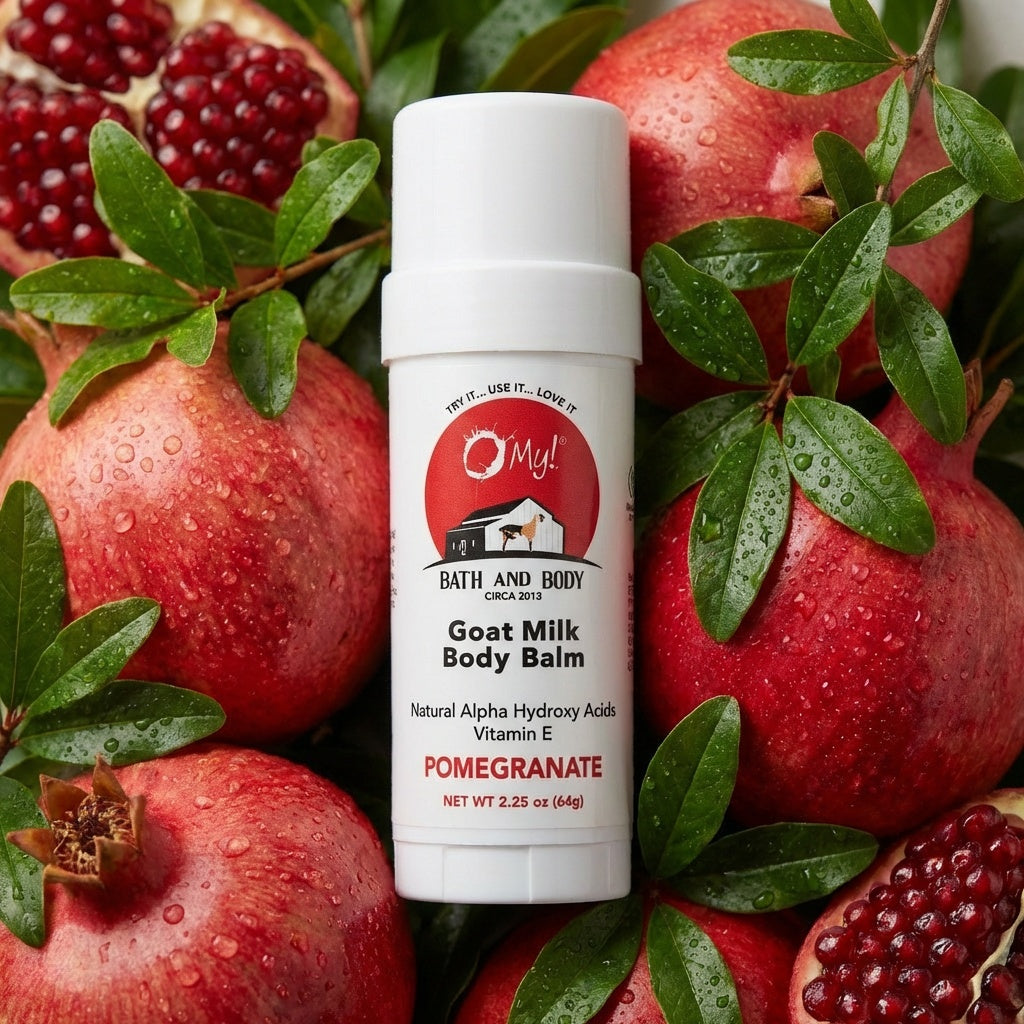 O My! Goat milk body balm Pomegranate twist tube with pomegranates and green leaves on a light green background.