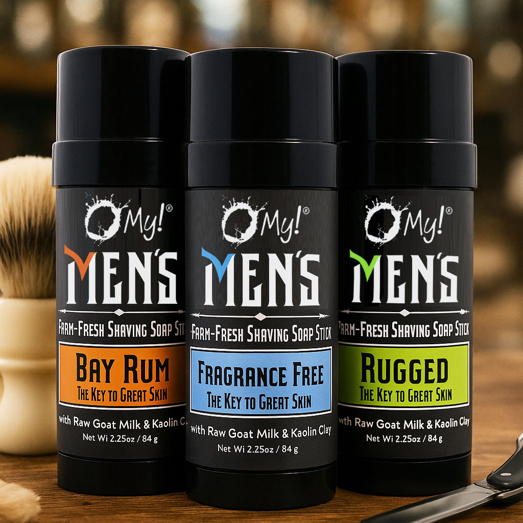 Three bottles of O My! Men's Shaving Soap Sticks with different scents on a wooden surface.