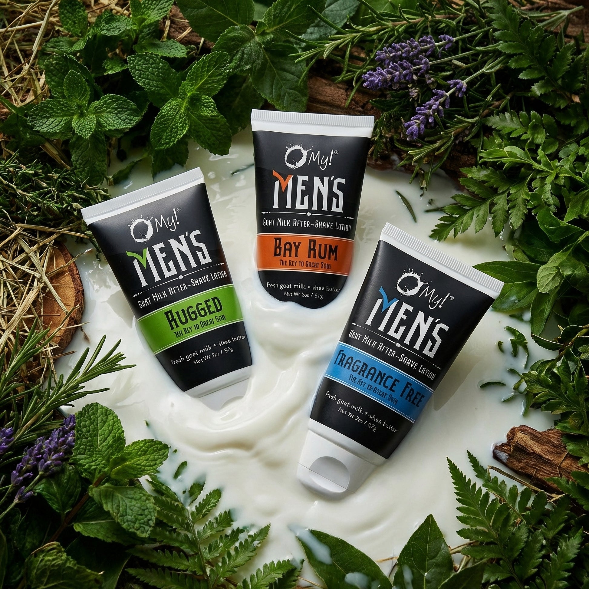 Three tubes of O My! Men's grooming after-shave lotion surrounded by greenery on a white, milky surface.