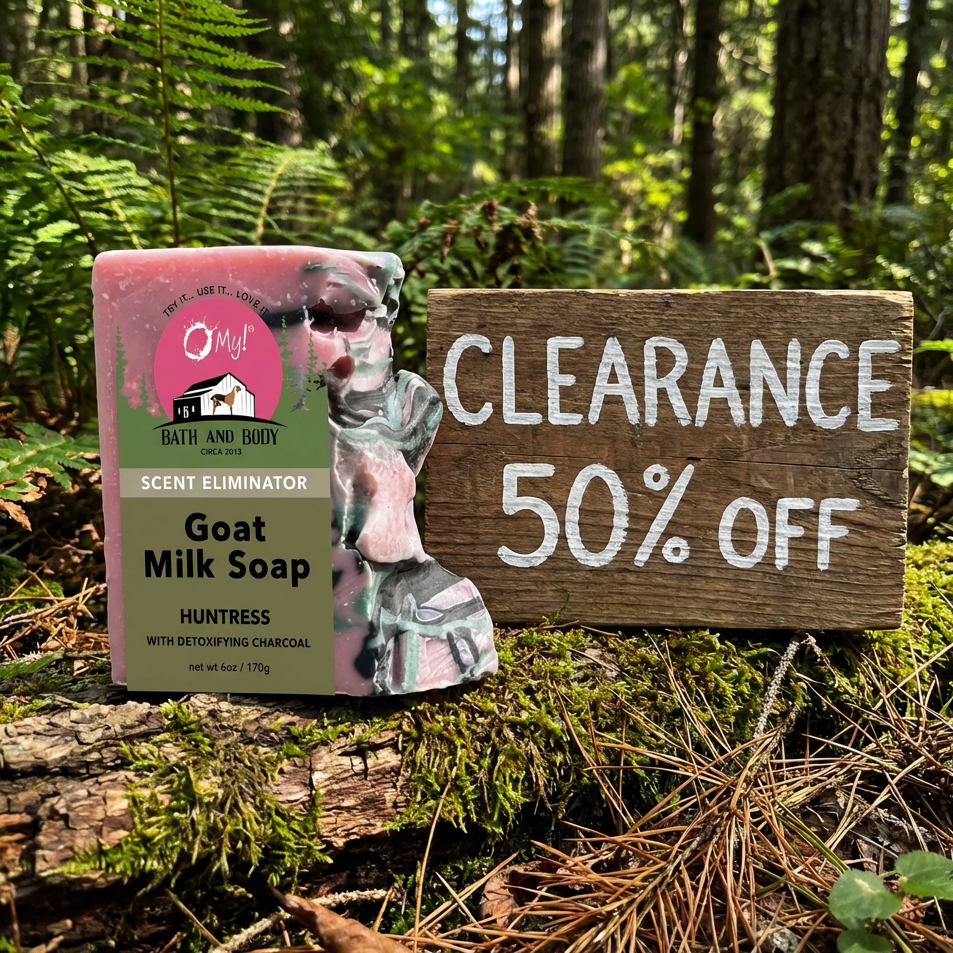 O My! Goat Milk Huntress soap packaging with a 'Clearance 50% Off' sign in a forest setting