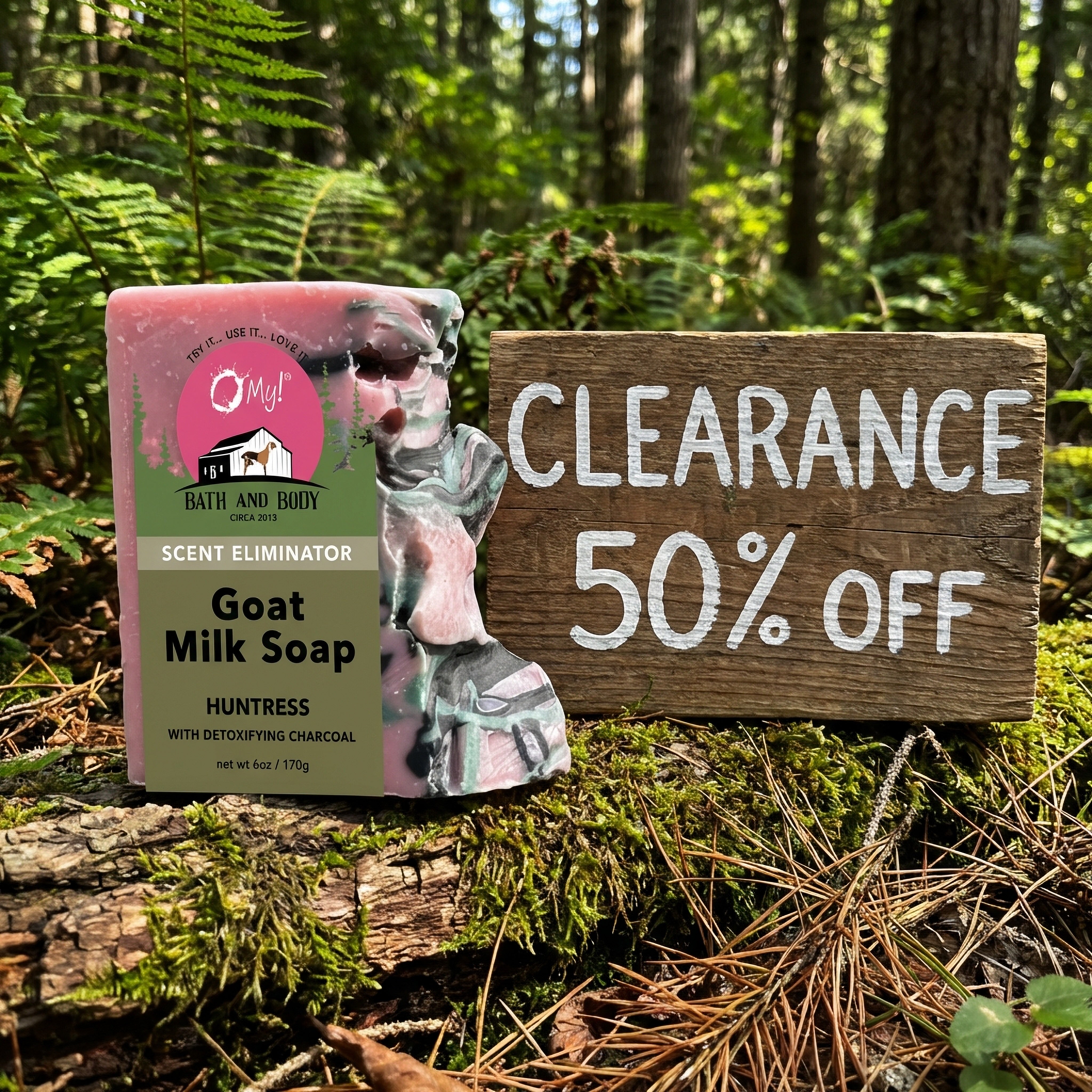 O My! Goat Milk Huntress soap packaging with a 'Clearance 50% Off' sign in a forest setting